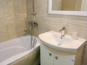 a bathroom with a sink and a bath tub and a sink at Guest House Barbov in Obzor