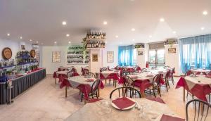 un restaurante con mesas, sillas y botellas de vino en Villa Pozzi, en Sestri Levante
