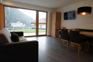 a living room with a couch and a table with chairs at Schlossbichl in Nauders