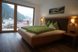 a bedroom with a bed with a large window at Schlossbichl in Nauders