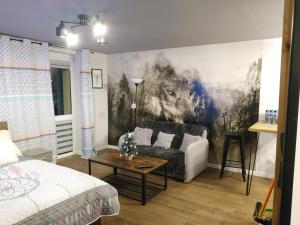 een woonkamer met een bank en een schilderij aan de muur bij Apartament Wataha in Ustrzyki Dolne