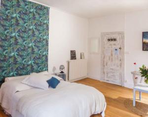 ein Schlafzimmer mit einem weißen Bett und einer grünen Wand in der Unterkunft Plume Et Pinceau in Montdragon