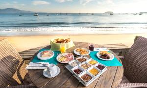 a table with plates of food on the beach at Pousada dos Sonhos in Florianópolis