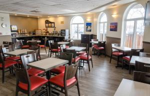 um restaurante com mesas e cadeiras e um bar em Days Inn & Suites by Wyndham Thunder Bay em Thunder Bay