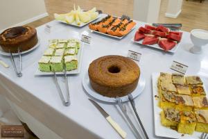 a table with many different types of cakes and desserts at Colonial Hotel Itatiba in Itatiba