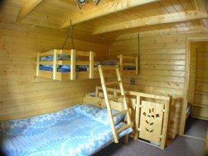 a bedroom with bunk beds in a log cabin at Mały domek pod lasem in Zakopane