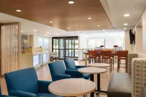 a lobby with tables and chairs and a kitchen at Holiday Inn Express Hartford South - Rocky Hill, an IHG Hotel in Rocky Hill