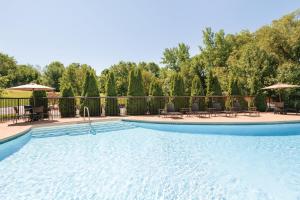 uma grande piscina com cadeiras e guarda-sóis em Holiday Inn Express Hartford South - Rocky Hill, an IHG Hotel em Rocky Hill