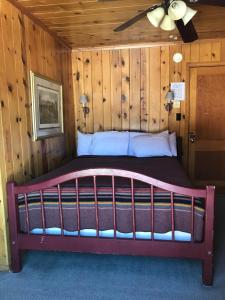 1 dormitorio en una cabaña de madera con 1 cama en The Lodge at Red River, en Red River