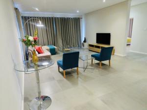 sala de estar con mesa, sillas y TV en The Executive - Exclusive Self-Catering Apartments - Ezulwini en Ezulwini