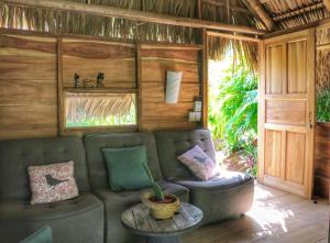 a living room filled with furniture and a couch at Glamping Hotel Flor y Bambu in Playa Grande