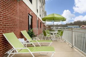 - une rangée de chaises et un parasol sur la terrasse dans l'établissement Holiday Inn Express Hotel & Suites Ashland, an IHG Hotel, à Ashland