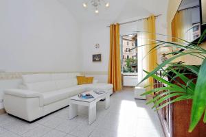 uma sala de estar com um sofá branco e uma mesa em GEMMA DOMUS em Roma
