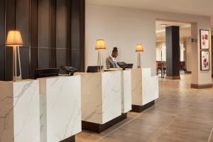a man sitting at a desk in a lobby at Crowne Plaza Dallas Market Ctr - Love Field, an IHG Hotel in Dallas +30 photos