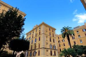 un grand bâtiment avec un palmier en face dans l'établissement GEMMA DOMUS, à Rome
