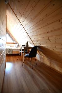 a room with a wooden ceiling and a table and chairs at Apartamenty Rogowcówka in Biały Dunajec
