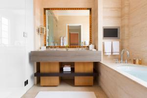 a bathroom with a sink and a tub and a television at Hotel Bel-Air - Dorchester Collection in Los Angeles