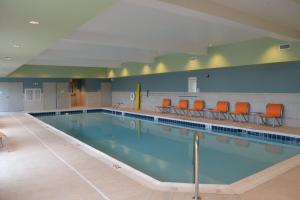 a large swimming pool with orange chairs in it at Holiday Inn Express & Suites Goodlettsville N - Nashville, an IHG Hotel in Goodlettsville