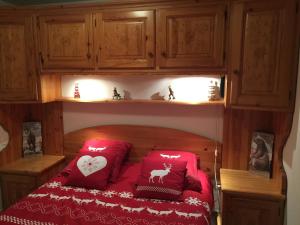 1 dormitorio con 1 cama con almohadas rojas en L'étable en Crévoux