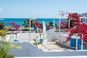 - une vue sur la plage depuis une maison ornée de fleurs roses dans l'établissement Pousada Mediterrânea, à Pipa