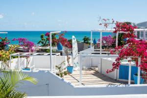 uma vista para a praia a partir de uma casa com flores cor-de-rosa em Pousada Mediterrânea em Pipa