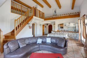 a living room with a leather couch and a staircase at villa de charme, 8 pers, climatisée, piscine chauffée, calme garanti in Roquebrune-sur-Argens