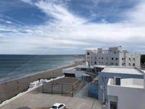 a view of a beach with white buildings and the ocean at Mirador Azul in Las Grutas