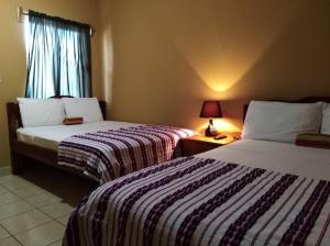 
A bed or beds in a room at Ambergris Sunset Hotel

