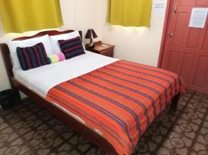
a bed room with a red and white bedspread at Ambergris Sunset Hotel in San Pedro
