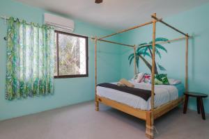 a bedroom with a canopy bed and a window at Casa Tropical in Cancún