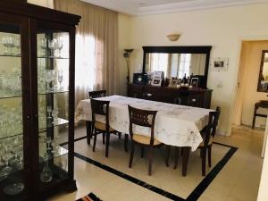 a dining room with a white table and chairs at Maison D'Hôtes villa Fatima in Tozeur