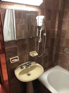 baño con lavabo y teléfono en la pared en Solana Del Mar en Las Grutas