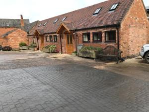 a brick building with a bench in front of it at Vale Farm in Higham on the Hill