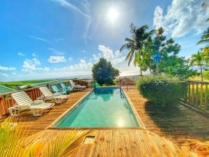 a swimming pool on a wooden deck with lounge chairs at Résidence Paradis Tropical in Basse-Terre