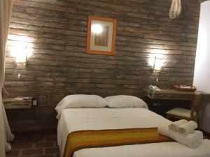 a bedroom with a bed and a wooden wall at Los Brunos Posada in Reconquista
