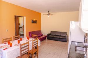 a dining room with a table and a couch at Apartamento Praia Grande Ubatuba 2 vagas garagem Internet WiFi in Ubatuba