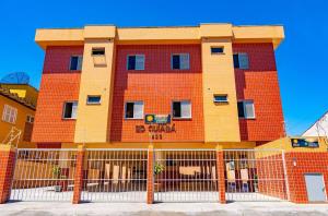 an orange brick building with a fence in front of it at Apartamento Praia Grande Ubatuba 2 vagas garagem Internet WiFi in Ubatuba