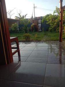 een stoel op een terras in de regen bij Sunrise Banyuwangi Homestay in Banyuwangi +1 foto