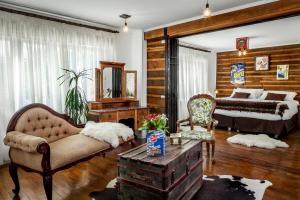 a bedroom with a bed and a couch and a table at Hotel Boutique La Yegua Loca in Punta Arenas