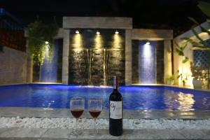 two glasses of wine sitting on a table next to a pool at Tan Doan An Bang center beach villas in An Bang