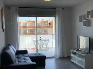 un salon avec un canapé et une grande fenêtre dans l'établissement Apartamento Nuevo Terrazas, à Granadilla de Abona