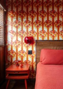 a bedroom with a bed and a table in front of a wallpaper at The Dive Motel and Swim Club in Nashville