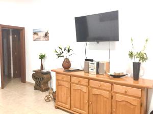 sala de estar con TV en la parte superior de un armario de madera en Samsara Home, en Caleta de Sebo