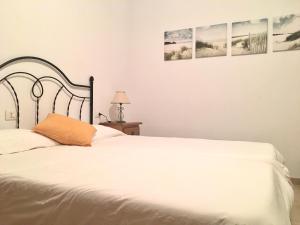 a bedroom with a white bed and three pictures on the wall at Samsara Home in Caleta de Sebo