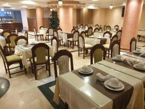 uma sala de jantar com mesas e cadeiras num restaurante em Hôtel Amouday em Casablanca