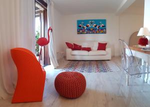 a living room filled with furniture and a red couch at Geco di Giada Art Suites - Adult Only in Porto Rotondo