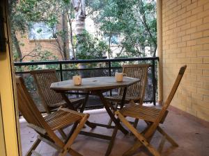 uma mesa de madeira e 2 cadeiras numa varanda em Escape to Strathfield for 8 guests em Sydney