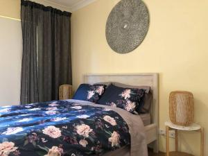 a bedroom with a bed and a clock on the wall at Escape to Strathfield for 8 guests in Sydney