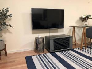a living room with a flat screen tv on the wall at Escape to Strathfield for 8 guests in Sydney