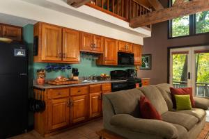 a living room with a couch and a kitchen at Paddler's Lane Retreat in Confluence